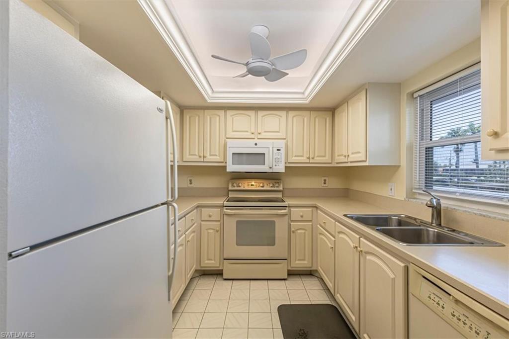 5483 Rattlesnake Hammock Road, Unit B201 Naples, FL 34113 - Photo 10 of 22 a kitchen with granite countertop a sink stainless steel appliances and cabinets