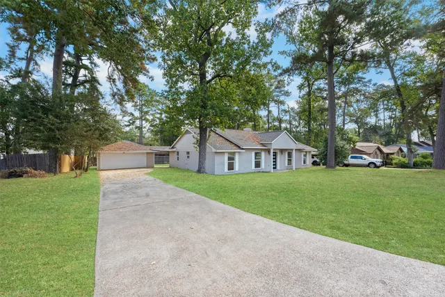 a front view of a house with a yard and trees