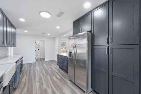 a kitchen with stainless steel appliances a refrigerator and wooden floor