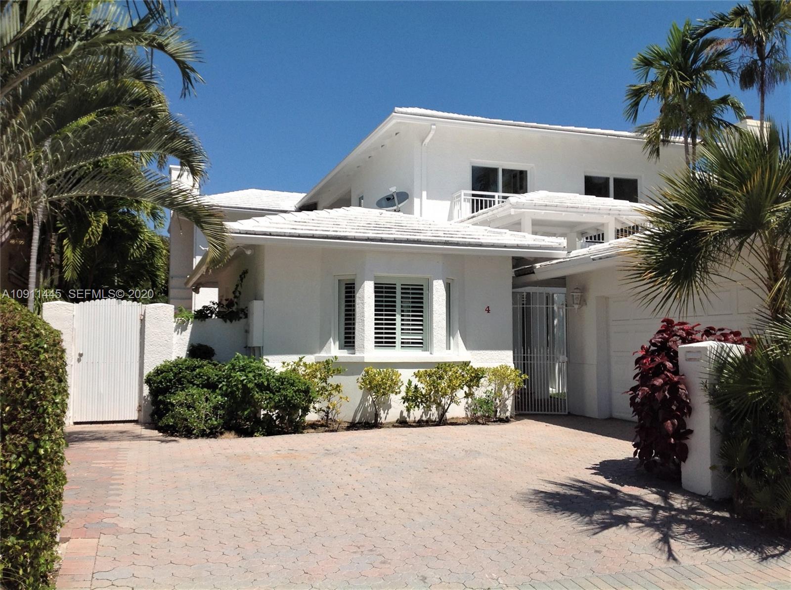 4 Turtle Walk, Unit 4 Key Biscayne, FL 33149 - Photo 1 of 54 a front view of a house with yard