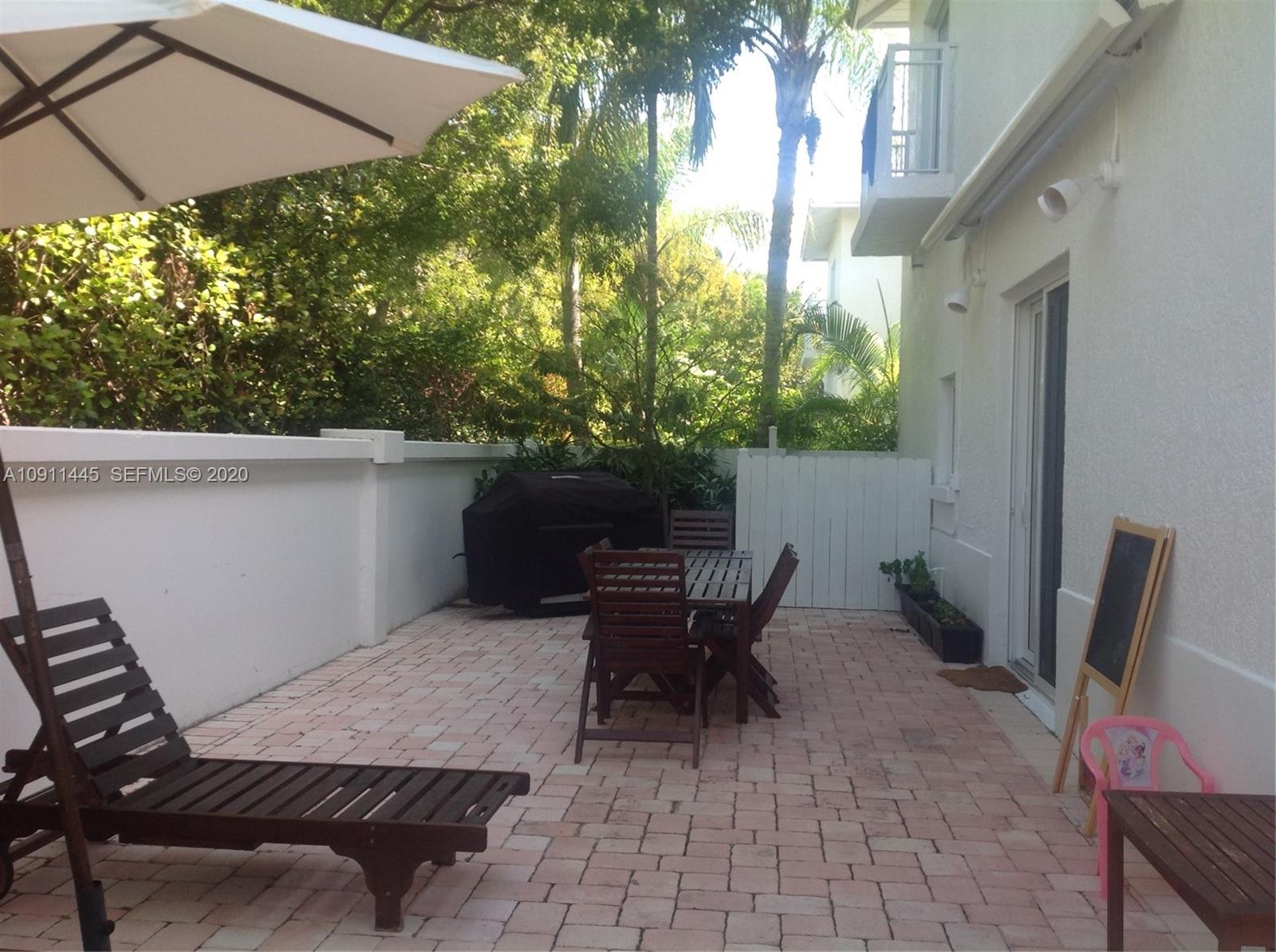 4 Turtle Walk, Unit 4 Key Biscayne, FL 33149 - Photo 15 of 54 a view of a patio with table and chairs and potted plants