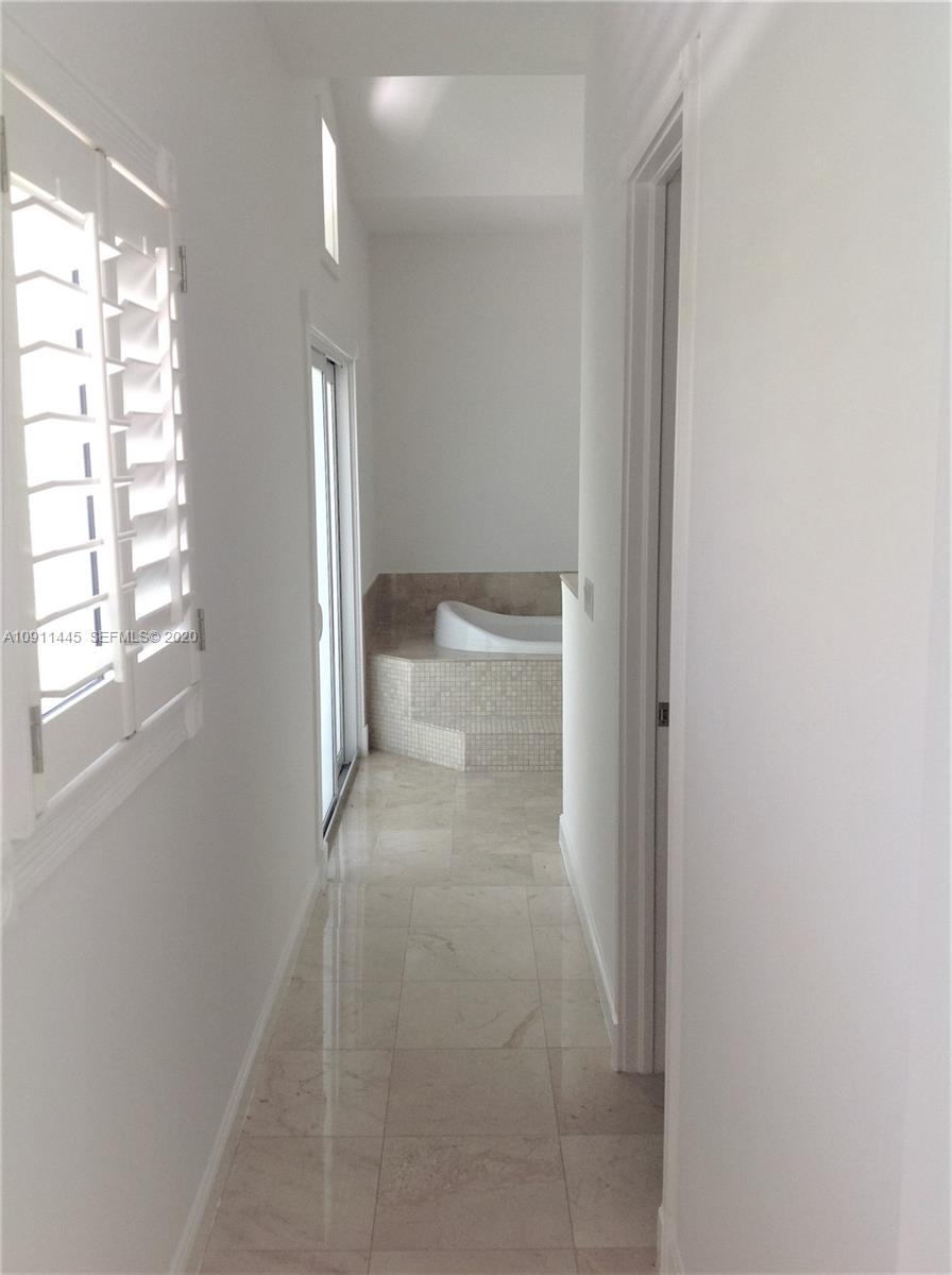 4 Turtle Walk, Unit 4 Key Biscayne, FL 33149 - Photo 27 of 54 a view of a bathroom from a corridor