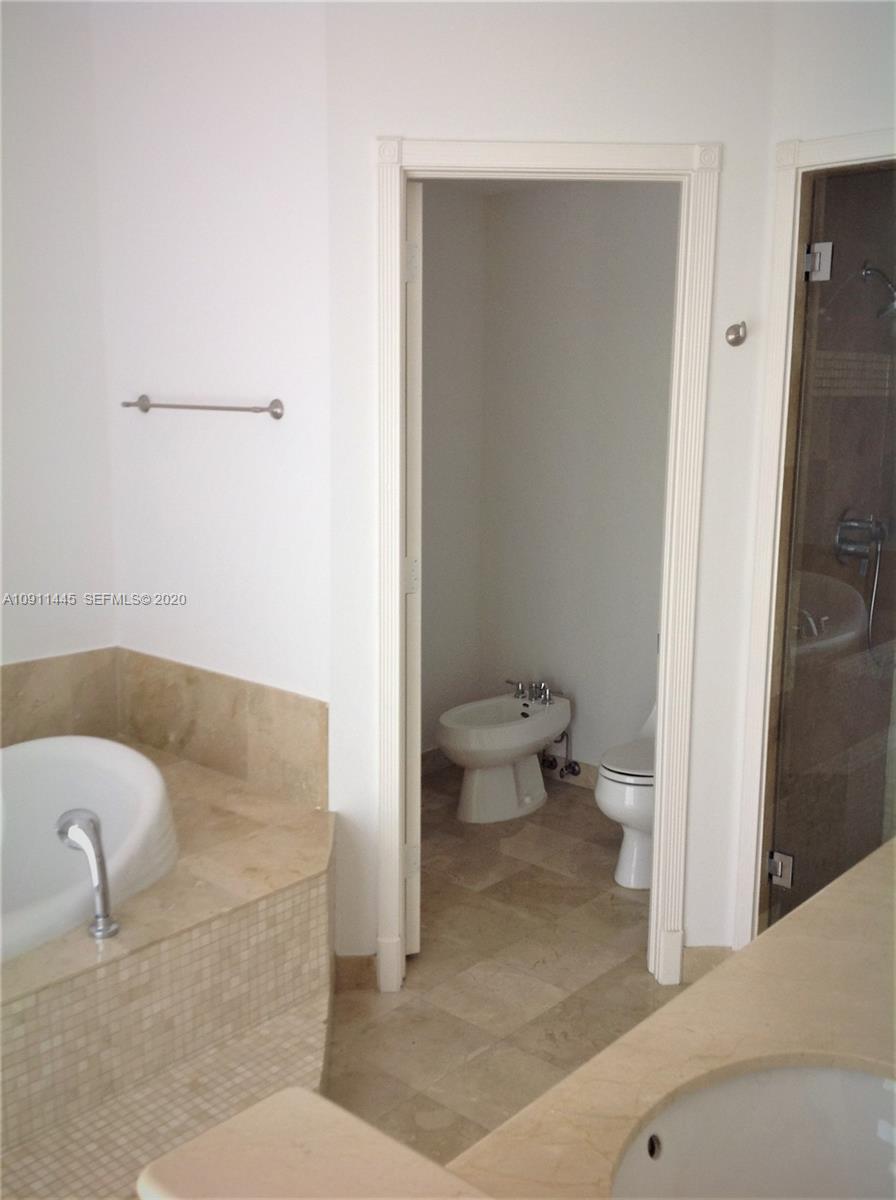 4 Turtle Walk, Unit 4 Key Biscayne, FL 33149 - Photo 30 of 54 a bathroom with a granite countertop bathtub and a toilet