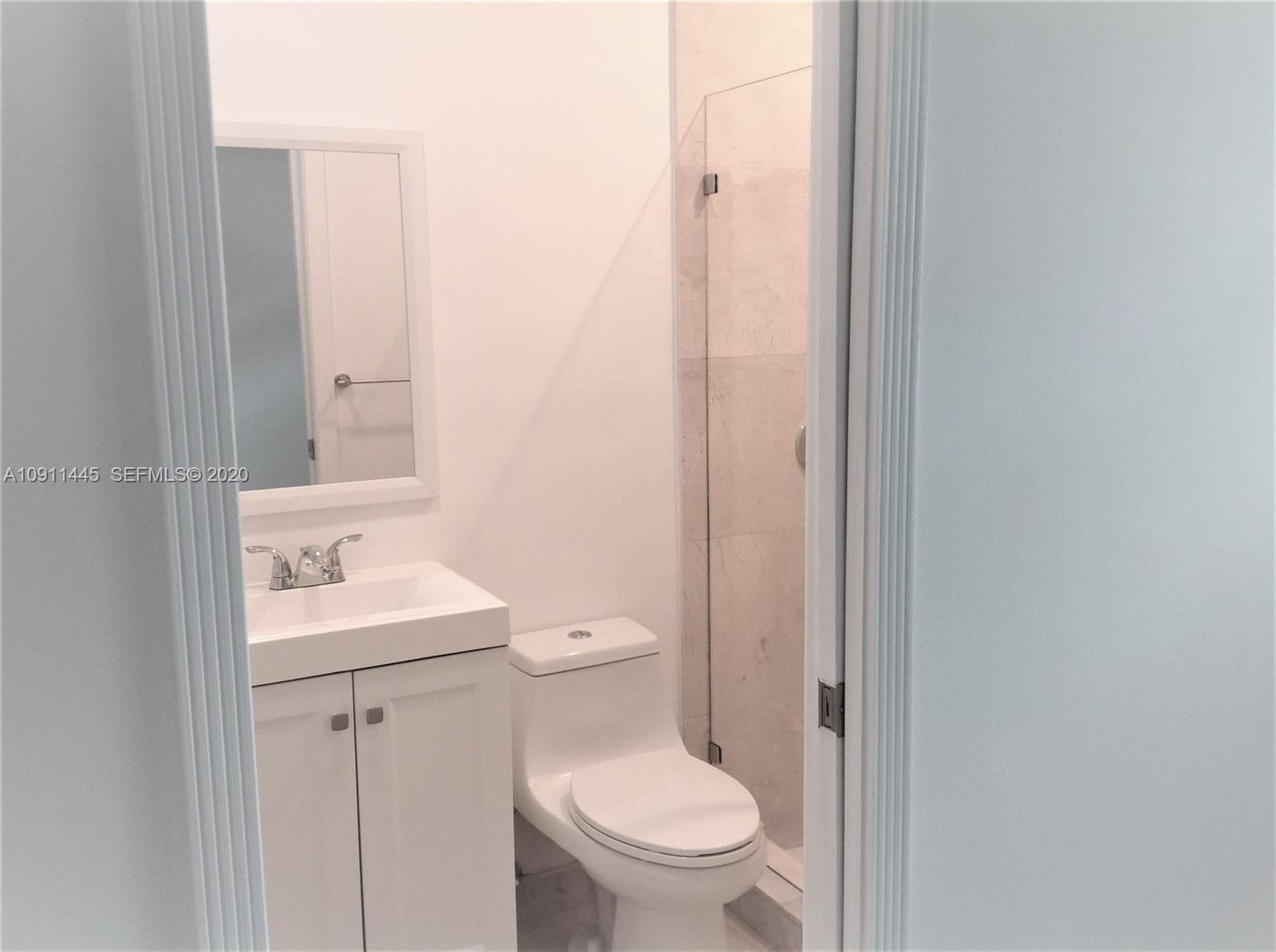 4 Turtle Walk, Unit 4 Key Biscayne, FL 33149 - Photo 51 of 54 a bathroom with a toilet a sink and a mirror