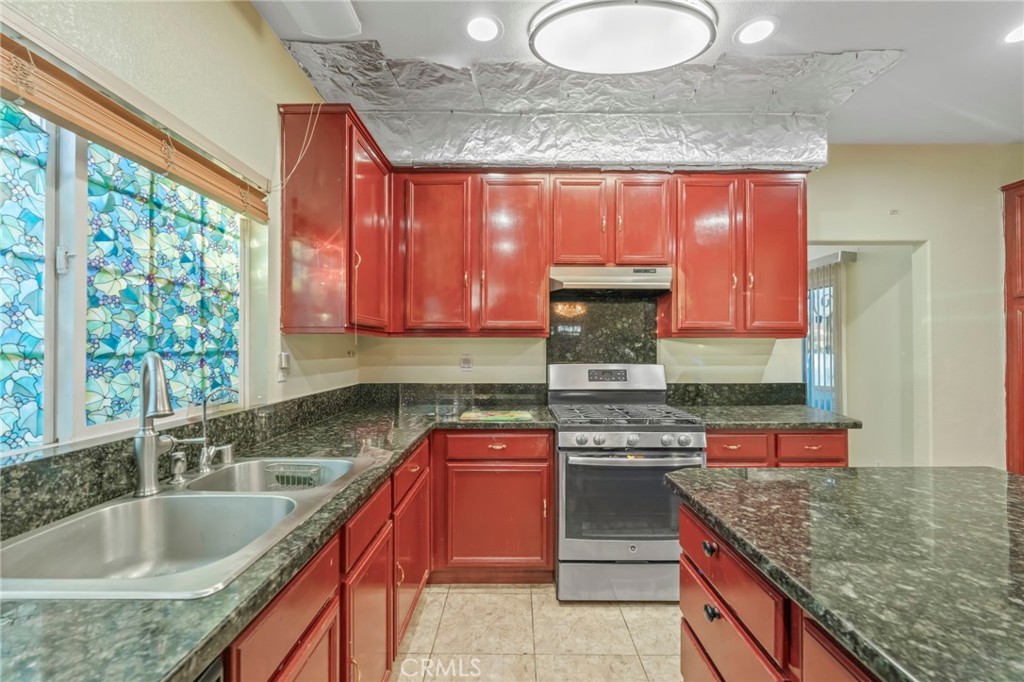 1553 West Ceres Street Rialto, CA 92376 - Photo 16 of 73 a kitchen with stainless steel appliances granite countertop a sink a stove and a wooden cabinets