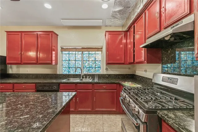 a dinning area with stainless steel appliances granite countertop a sink and a refrigerator