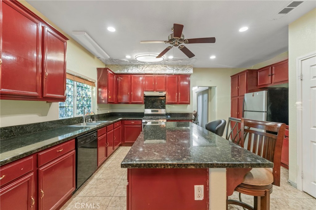 1553 West Ceres Street Rialto, CA 92376 - Photo 20 of 73 a kitchen with stainless steel appliances granite countertop a sink dishwasher a stove a refrigerator with a dining table and chairs