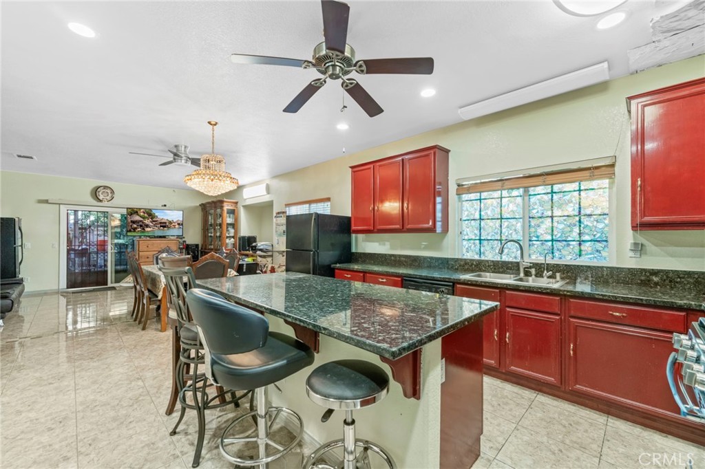 1553 West Ceres Street Rialto, CA 92376 - Photo 22 of 73 a kitchen with stainless steel appliances granite countertop a sink a stove a dining table and chairs with wooden floor