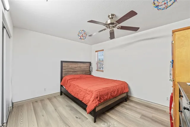 a bedroom with a bed a chair and a chandelier