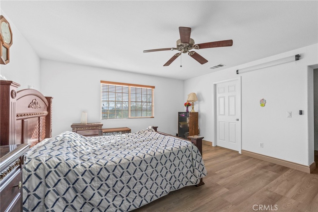 1553 West Ceres Street Rialto, CA 92376 - Photo 29 of 73 a bedroom with a large bed and a chandelier