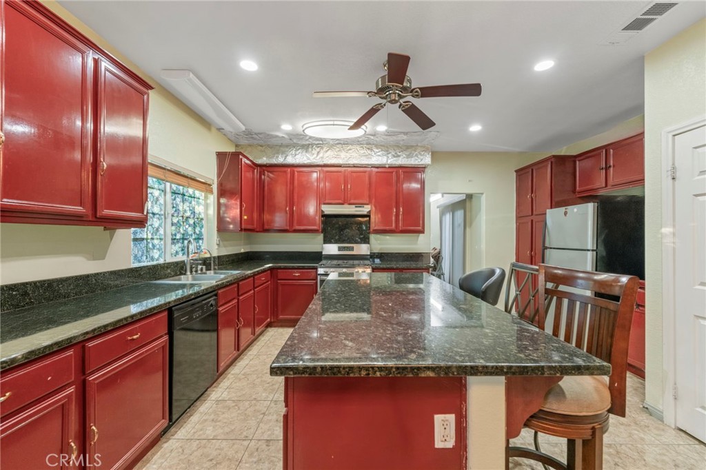 1553 West Ceres Street Rialto, CA 92376 - Photo 3 of 73 a kitchen with stainless steel appliances granite countertop a sink dishwasher a stove a refrigerator with a dining table and chairs