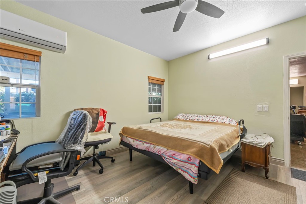 1553 West Ceres Street Rialto, CA 92376 - Photo 32 of 73 a bedroom with a bed a chair and a chandelier