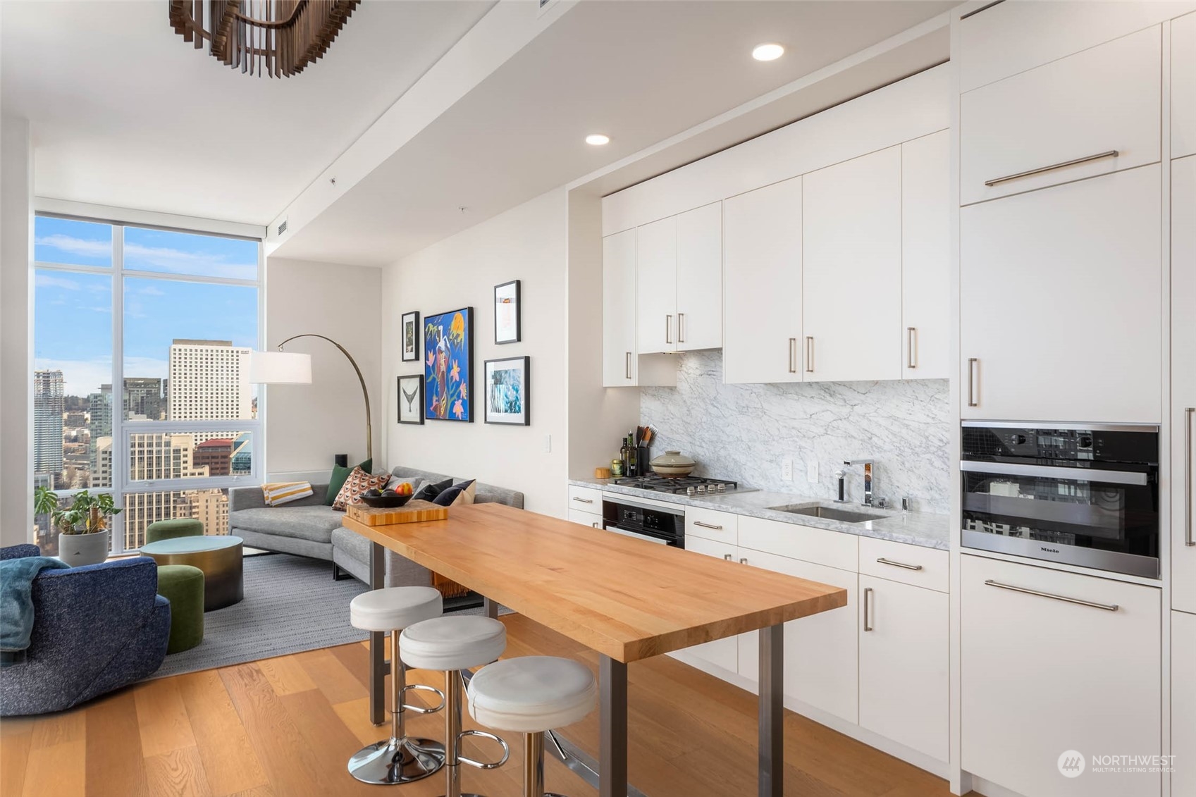 121 Stewart Street, Unit 3501 Seattle, WA 98101 - Photo 5 of 21 a room with stainless steel appliances kitchen island granite countertop a stove a sink a refrigerator and white cabinets with wooden floor