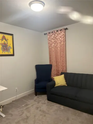 a living room with furniture and a air conditioner vent