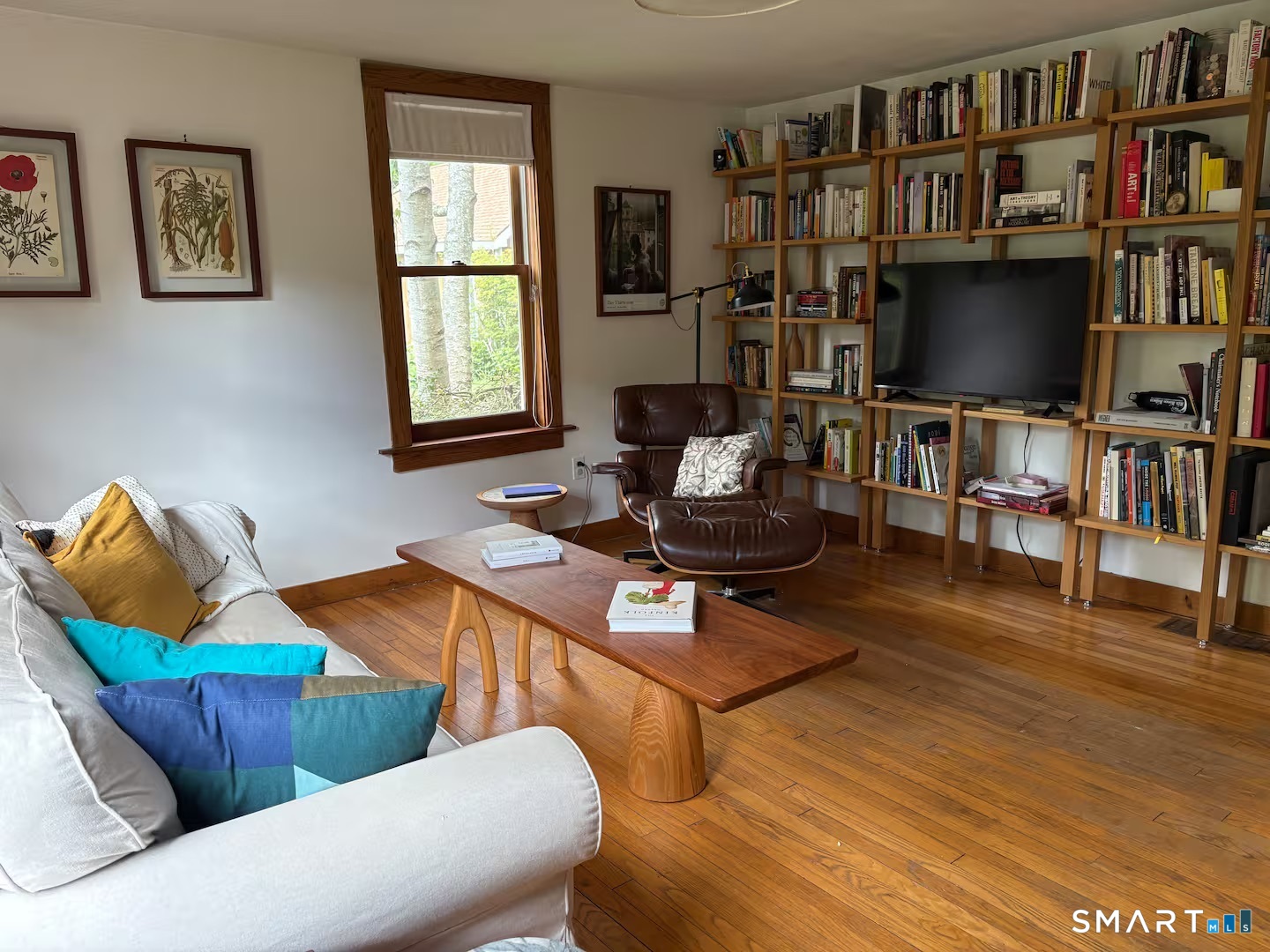 895 Tolland Stage Road Tolland, CT 06084 - Photo 11 of 33 a living room with furniture a flat screen tv and a book shelf
