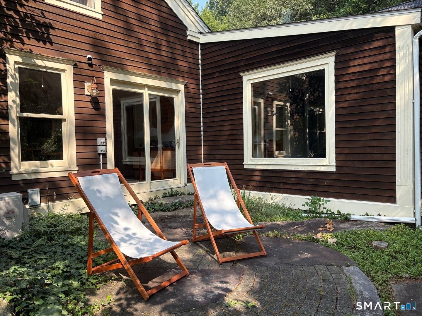 895 Tolland Stage Road Tolland, CT 06084 - Photo 30 of 33 front view of a house with a chairs and table in a patio