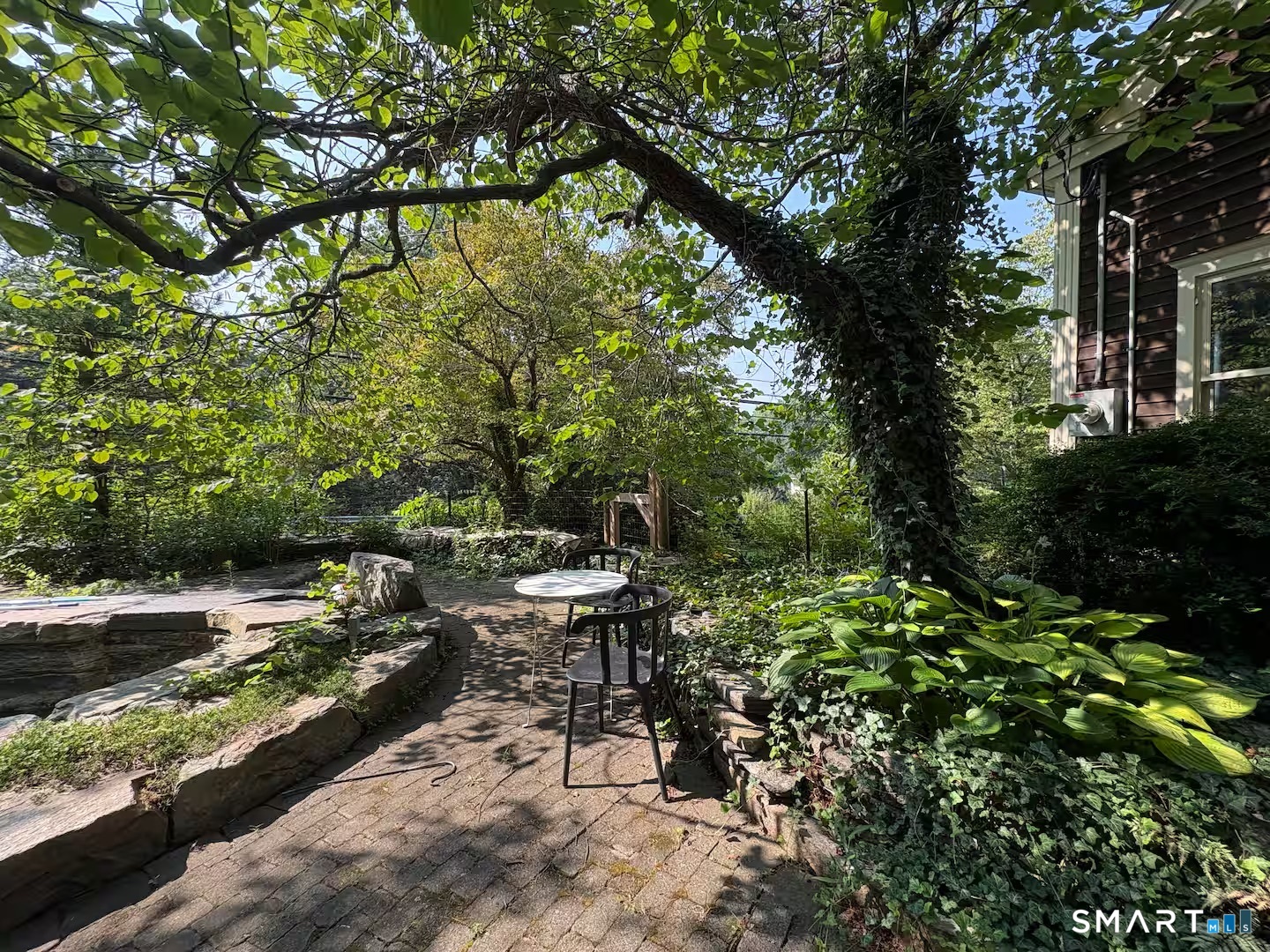 895 Tolland Stage Road Tolland, CT 06084 - Photo 32 of 33 a view of a yard with plants and a bench