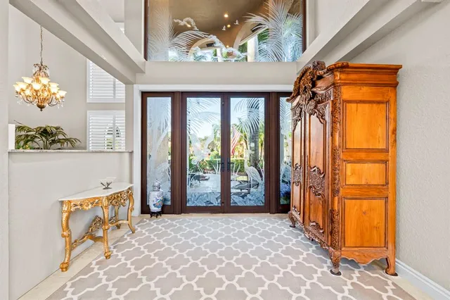 a living room with furniture kitchen view and a chandelier
