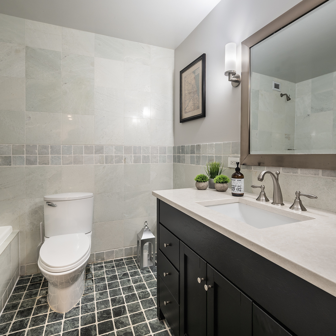 1030 North State Street, Unit 2GH Chicago, IL 60610 - Photo 26 of 36 a bathroom with a double vanity sink toilet and a mirror