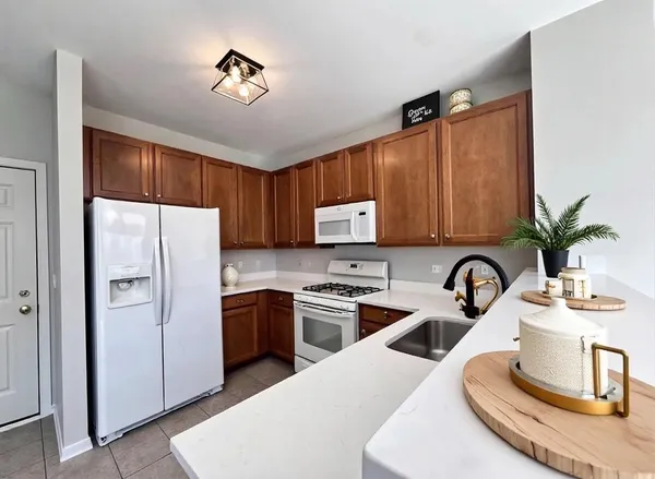 a kitchen with stainless steel appliances a sink a refrigerator a stove a microwave and cabinets