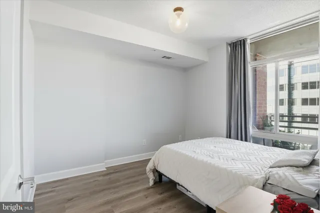 a bedroom with a bed and a large window