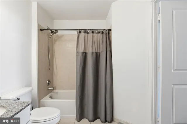 a bathroom with a shower curtain and a toilet