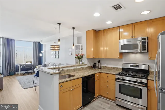 a kitchen with stainless steel appliances granite countertop a sink stove and cabinets