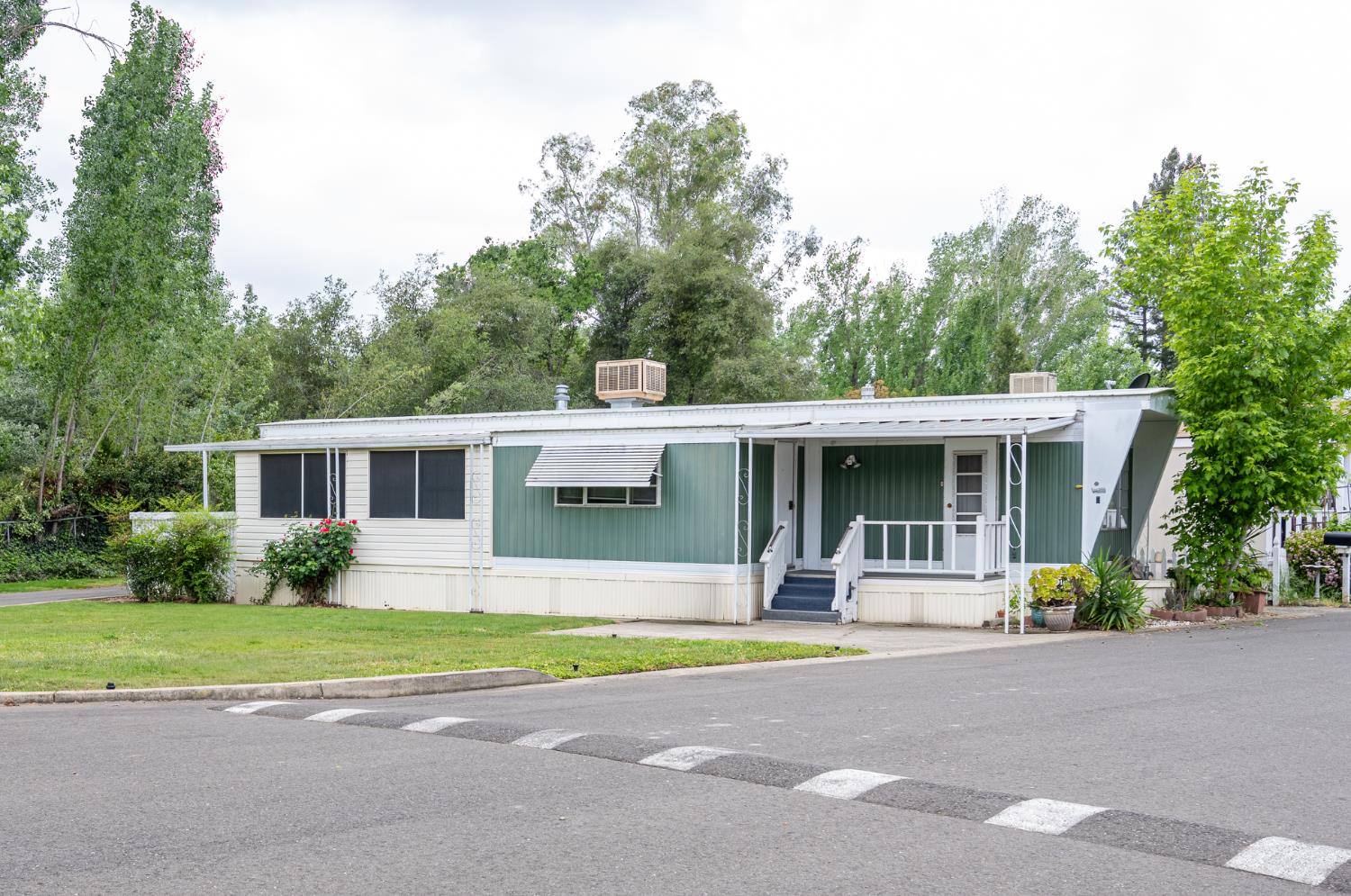 a front view of house with yard and trees in the background