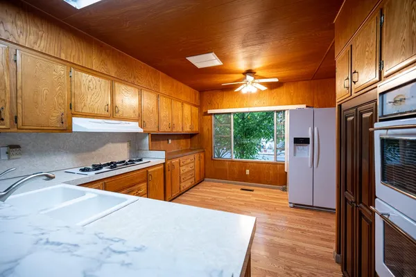 a kitchen with stainless steel appliances granite countertop a stove a sink and a refrigerator