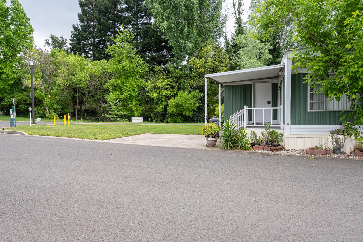 9060 Auburn Folsom Road, Unit 1 Granite Bay, CA 95746 - Photo 3 of 27 a view of a house with a yard and large trees