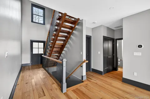 a view of a hallway with wooden floor and staircase