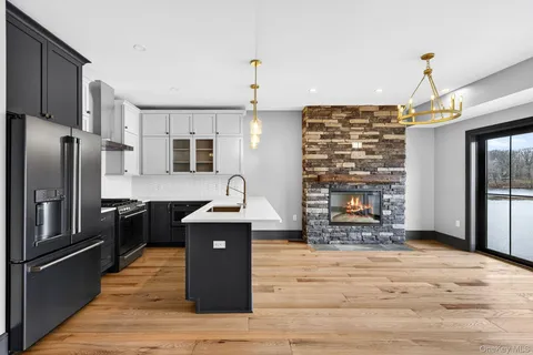 a kitchen with stainless steel appliances granite countertop a refrigerator a stove and a wooden floors