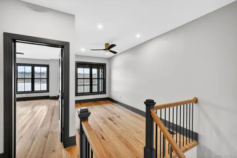 a view of hallway with wooden floor and stairs