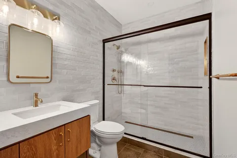 a bathroom with a sink mirror toilet and shower