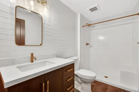 a bathroom with a sink a toilet and shower