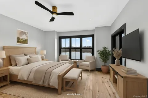 a bedroom with a bed a large window and flat screen tv