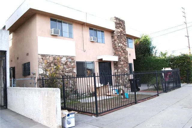 a view of a house with a small yard and wooden fence