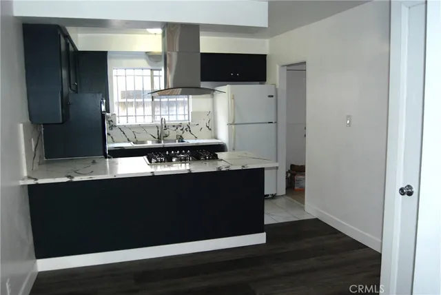 a kitchen with a sink and wooden floor