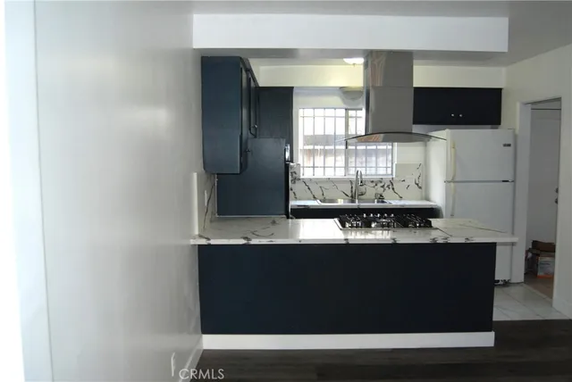 a kitchen with kitchen island sink and refrigerator