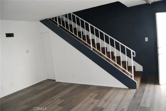 a view of staircase with lots of wooden floor and white walls