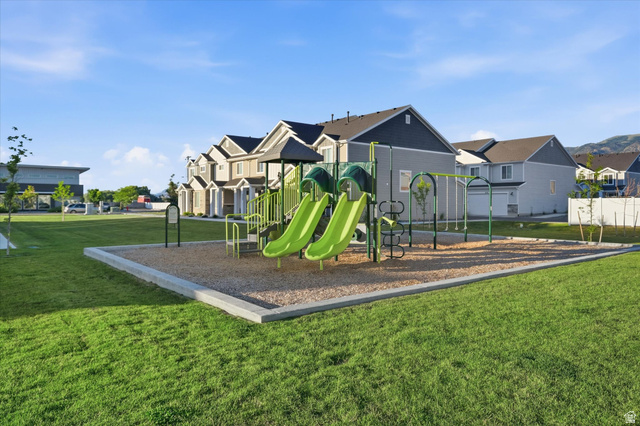 2257 South 1090 West, Unit 74 Nibley, UT 84321 - Photo 25 of 40 Community playground featuring multiple slides and swings on a gravel surface