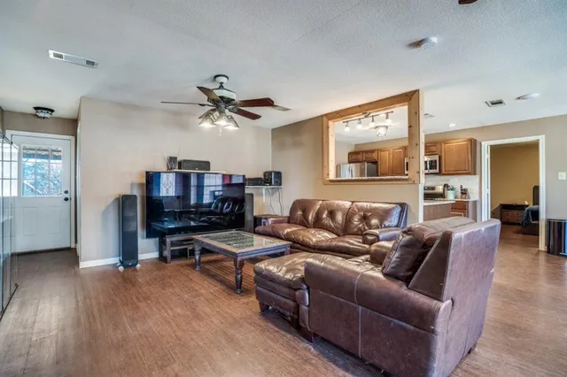 a living room with furniture and a wooden floor