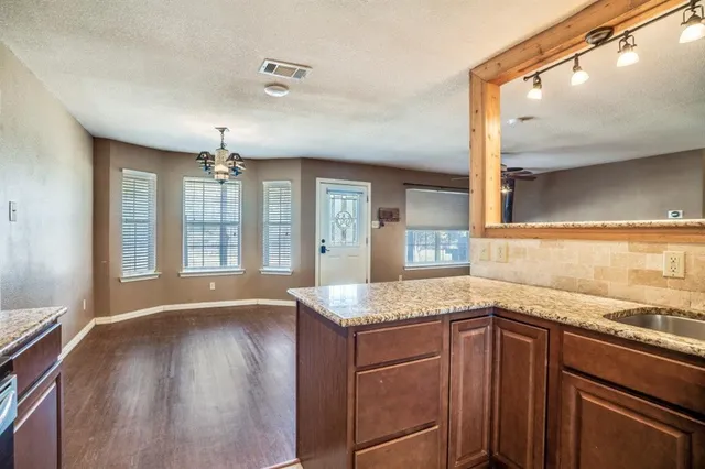 a kitchen with granite countertop a sink and a stove