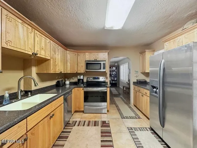 a kitchen with stainless steel appliances granite countertop a refrigerator stove microwave and sink