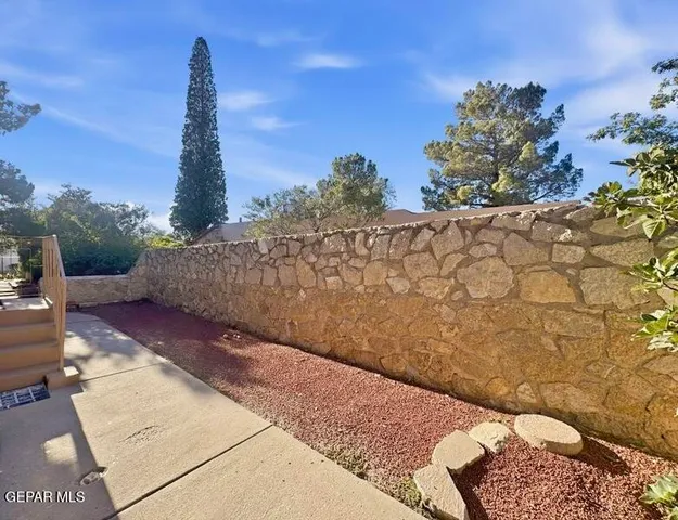 a view of a pathway with a wrought fence