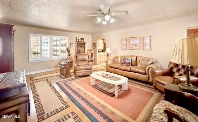 a spacious bedroom with a bed a couch and a chandelier