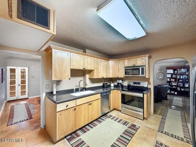 a kitchen with stainless steel appliances granite countertop a sink stove and cabinets
