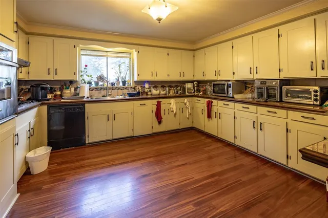 a kitchen with wooden floors and white appliances