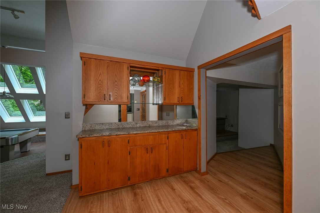7061 Cascade Road Painesville, OH 44077 - Photo 24 of 49 Kitchen with light wood-type flooring, a skylight, high vaulted ceiling, and rail lighting