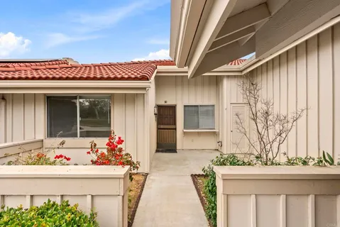 a front view of a house with plants